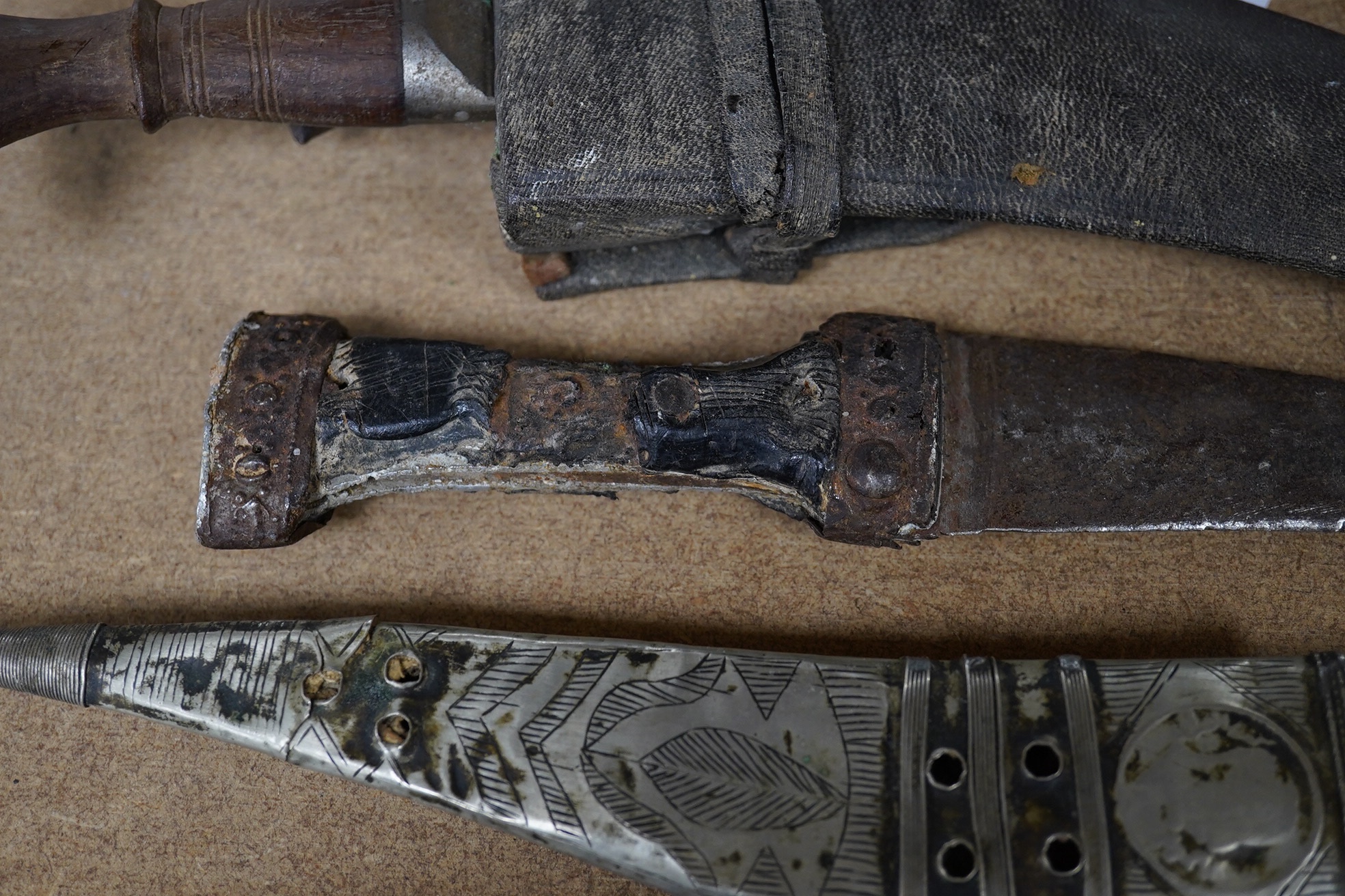 Three daggers, two with sheaths and a kukri knife, largest 33cm in length. Condition - poor